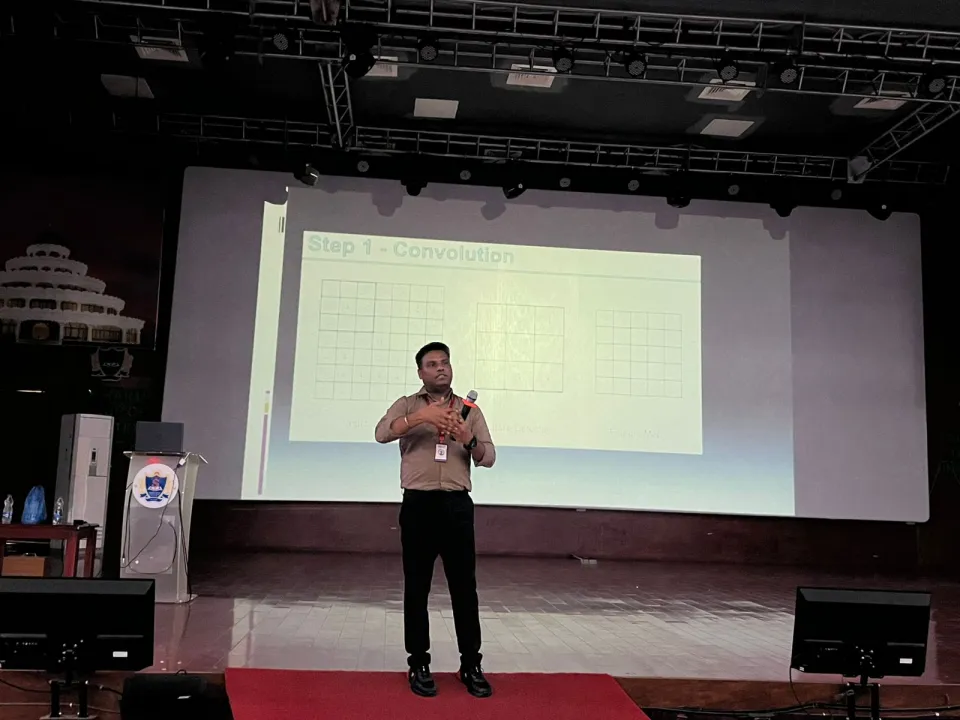 A presenter speaking on stage during a campus session